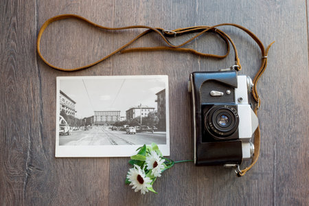 old camera and a black and white photo on a wooden table