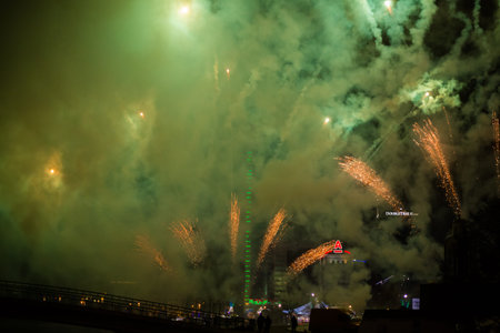 Explosive and colorful holiday fireworks at night sky. Celebration City Holiday. Pyrotechnic smoke...