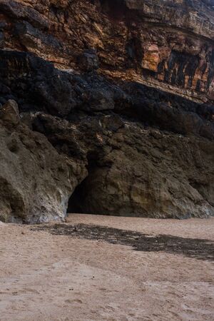 Beach of Nazare, Portugal. Cliff and sand. Caves in the rockの写真素材