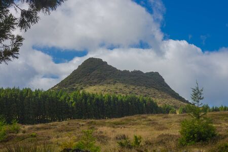 Double Hill over fields with blue sky and clouds near gruta do Natal in municipality of Praia da Vitoria, on the island of Terceira in Portuguese archipelago of the Azores.の写真素材