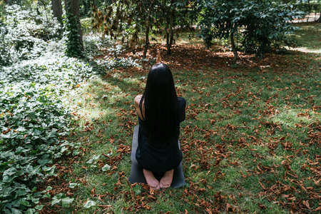 a girl doing yoga in nature dressed in blackの写真素材