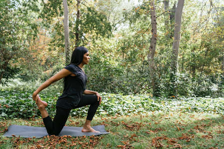 girl practicing yoga in a very beautiful forestの写真素材