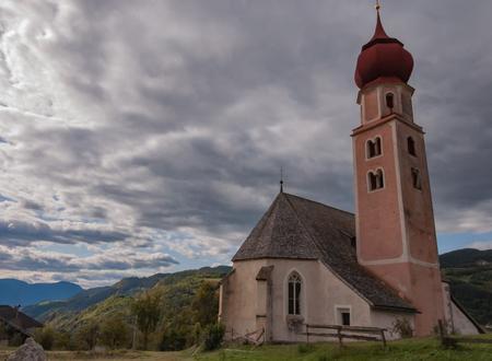 Picture showing St. Osvaldo church, a quiet place over the Dolomiti mountains.の写真素材
