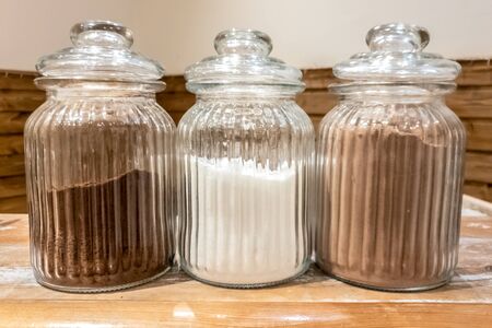 Three glass jars full of cafe, sugar and cacao. Hot drinks.の写真素材