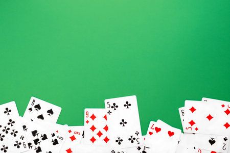 Deck of playing cards on green background table copy space