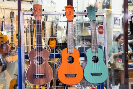 GREECE, AEGINA ISLAND - NOVEMBER 30, 2019: Three multi-colored small guitars ukulele on a local marketのeditorial素材
