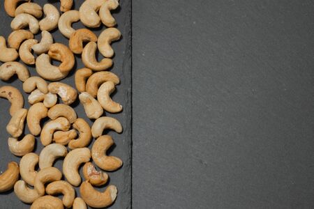 Salted cashew nuts on a black background.の写真素材