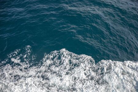 Sea water with foamy surface, foam on the blue , sea background waves.の写真素材