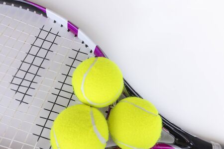 Tennis racquet and three balls with copyspace top view onwhite background. Playing tennis equipment.の写真素材
