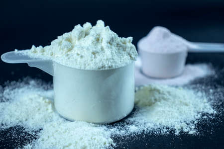 Whey protein powder scoop. Sports nutrition on black backgroundの写真素材