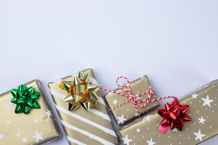 Presents and gift boxes with copy space on white background top view, craft wrapping with stars and stripes, silver, red and green bow.の写真素材