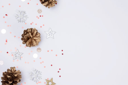 Christmas background with golden pine cones, stars and snowflakes on white background with copy...
