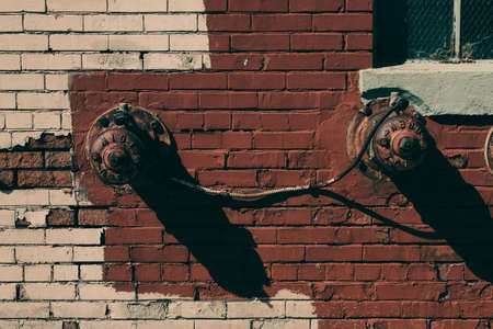 Antique sprinkler system on a painted urban brick wallの写真素材