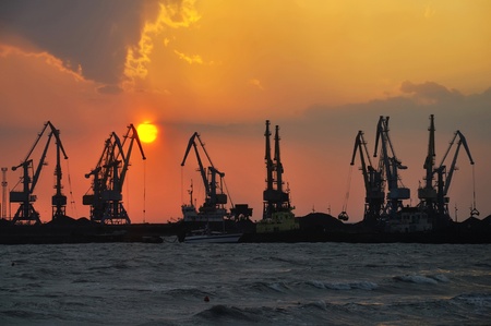 Port cranes at sea at the setting sun (at the end of the day)のeditorial素材