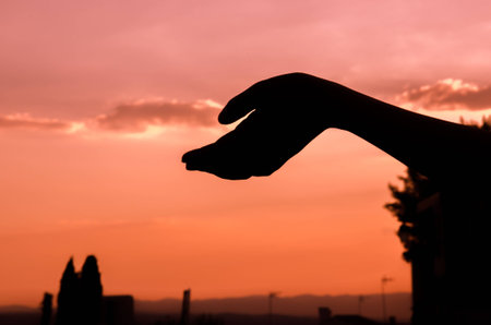 Hand over sunset with shadowsの写真素材