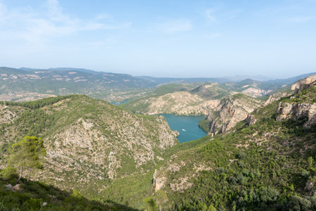 Beautiful landscape photo of the cortes del pallas reservoir with a boat on the water and beautiful vegetation and trees everywhere, Valencian community, Spainの写真素材