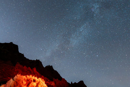 Beautiful night photograph with a clear and starry sky, with the Milky Way and an illuminated and...