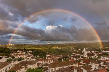 Full rainbow in the city of Obidos Portugalの写真素材