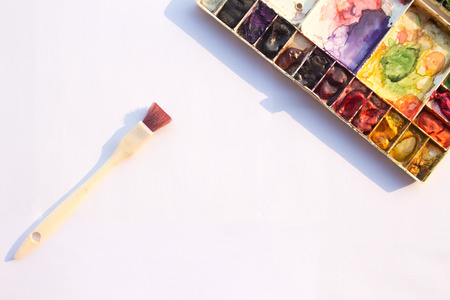 Plate for mixing watercolors filled with many colors of dry paint.Â 
Watercolor tray and brush on white background.の写真素材