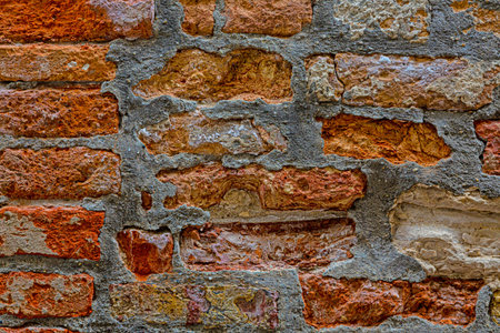 Macro picture of red colored natural brick wall with grey cement joints with natural light