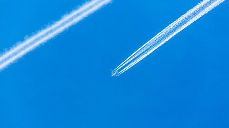 Two engined airplane during flight with condensation trails