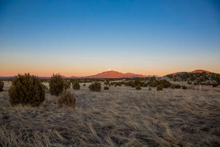 Full moon rises over Humphreys Peak near Grand Canyon in Arizona in the evening at wintertimeの写真素材