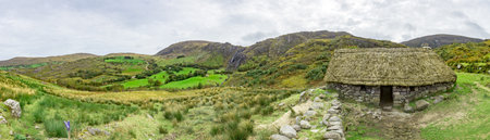 Panorama picture of typical Irish landscape with medieval stone houseの写真素材