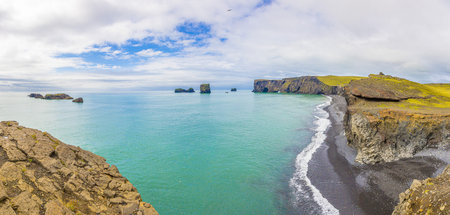 View on natural arches at Reynisfjara black beach in southern Iceland in summer