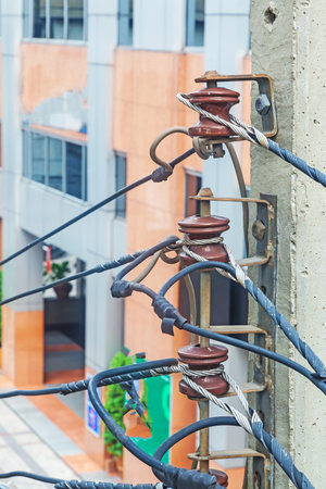 Chaotic cable routing of electricity and telephone cables on a main street in bangkok during daytime