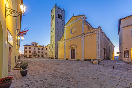 Panorama over the central square of Motovun with St. Stephen's church and city gate during at sunrise in summerの写真素材