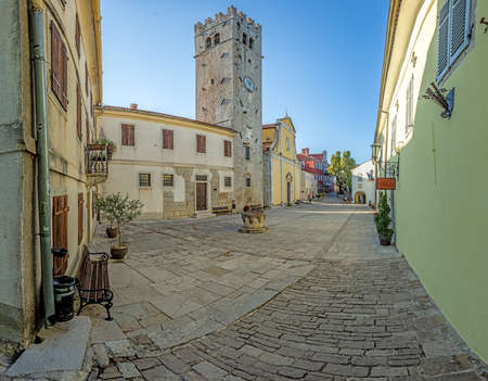 Panorama over the central square of Motovun with St. Stephen's church and city gate during at sunrise in summerの写真素材