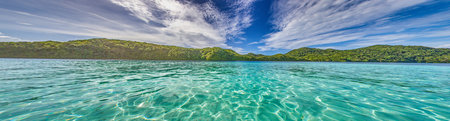 Panoramic view over turquoise blue water to a tropical island in Palau during daytimeの写真素材