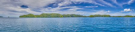 Panoramic view over turquoise blue water to a tropical island in Palau during daytimeの写真素材