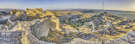 Panoramic image of the fortification above the historic town of Monsanto in Portugal during summer sunriseの写真素材