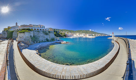 Scenic view of Bastia harbor wall and entrance with lighthouse under a bright blue sky in summerの写真素材
