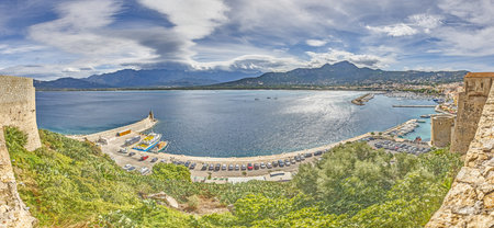 View from the fortress of Calvi in Corsica overlooking the coastline and the sea with mountains in...