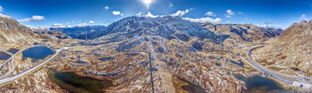 Drone panorama of Gotthard Pass in Switzerland with surrounding mountains and wind turbines in summerの写真素材