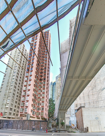 Dense urban architecture in Hong Kong with tightly packed high-rise buildings under a bright sky, in year 2014の写真素材