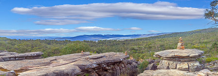 Rock formations in Blue Mountains with cairns, dense forests, and mountains in the distance during...