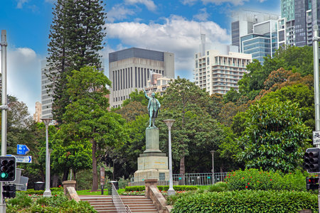 Historic statue of James Cook surrounded by modern skyline and green trees in Sydney during daytimeの写真素材
