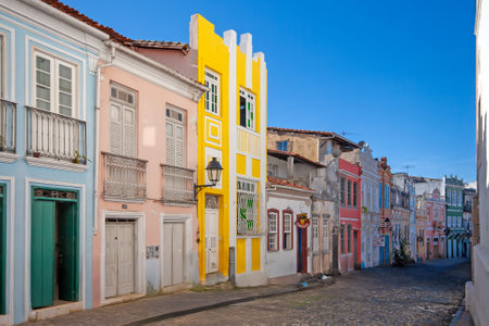 Vibrant colonial street in Salvador de Bahia with colorful houses under a blue sky during daytimeの写真素材