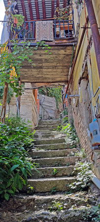 Rustic stone staircase leading to an old balcony with plants and vintage details in daylightの写真素材