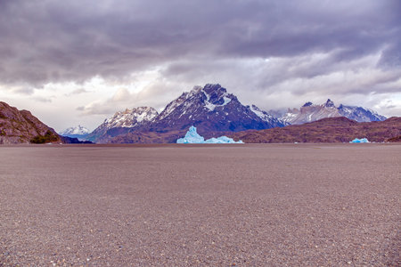 View from the far end of Lago Gray with icebergs and dramatic mountain backdrop in Torres del Paine during daytimeの写真素材