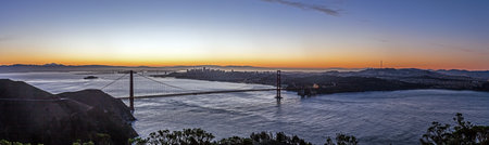 Golden Gate Bridge at sunset with San Francisco skyline in the background in winter