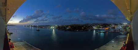 Wide view over city of Roseau and coastline from cruise ship deck at sunsetの写真素材