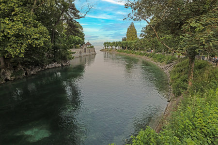 Quiet Seerhein canal in Konstanz with historic walls and lush trees and no people in sight
