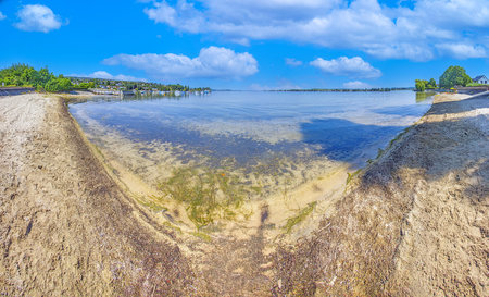 Sandy beach with clear water at Ermatingen on Lake Constance with village view