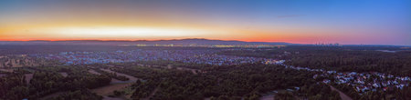Wide panorama of Frankfurt area with houses, forests and sunset colors in the sky