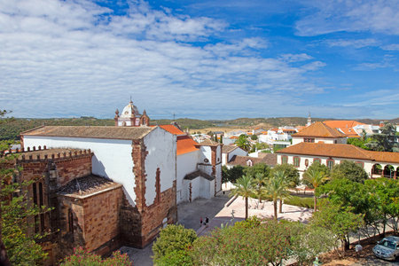 Archaeological ruins and towers inside Silves castle with red stone walls palms and blue sky in Algarve Portugal.の写真素材