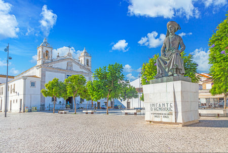 Historic statue of Infante Dom Henrique and church of Santa Maria on square in Lagos Algarve Portugalの写真素材